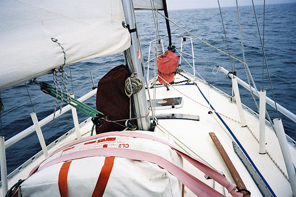 The sails rigged and bagged for a quick deployment. A small Jibb forward and the storm sail on it's own track on the mast. (note the 6 man life raft strapped down on the deck).